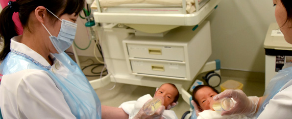 赤ちゃんを抱く看護師の写真