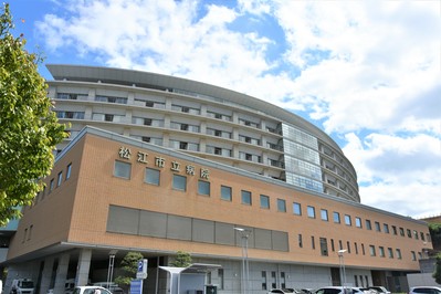 青空の下に建つ市立病院の建物の画像