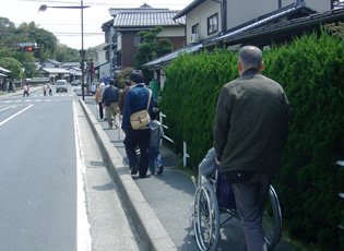 天気の良い日に歩道を歩く車いすのメンバーたち