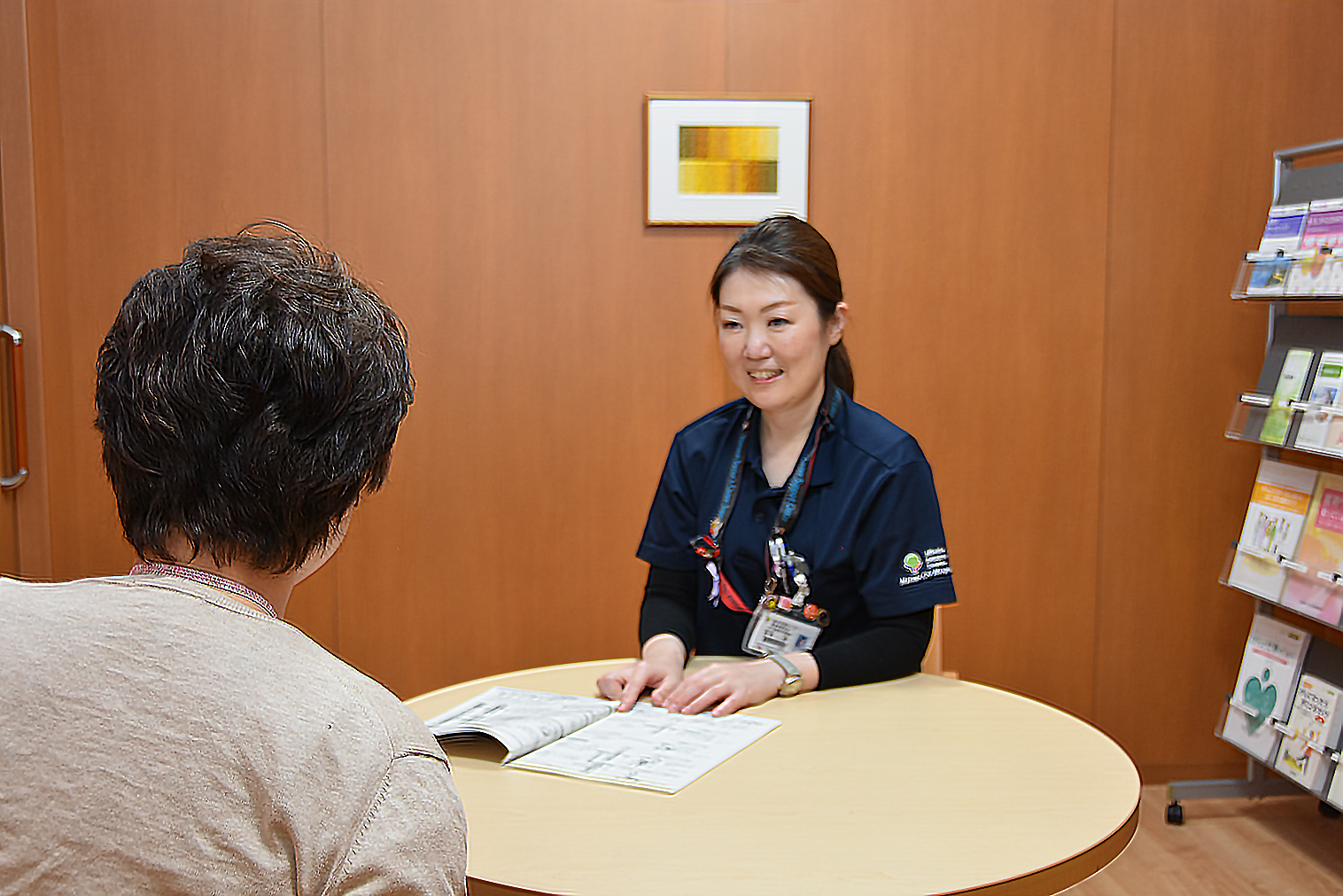 相談者とパソコンを操作しながら会話する相談員の女性