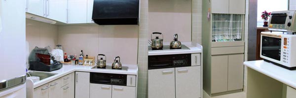 IHヒーターの上に2つのやかんが乗っており食器乾燥機、冷蔵庫がある