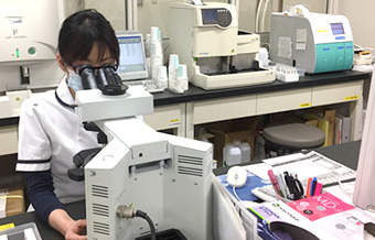 調べる検査部の女性
